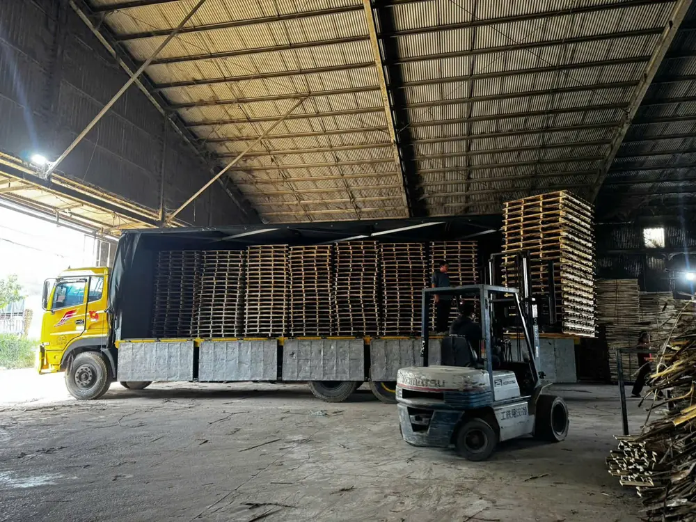 xe tải và xe nâng bốc pallet gỗ chuẩn bị xuất hàng