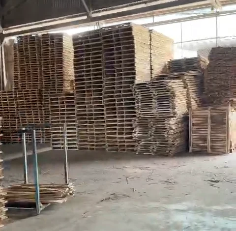 các chồng pallet gỗ tràm xếp cao trong kho xưởng Hoàng Gia