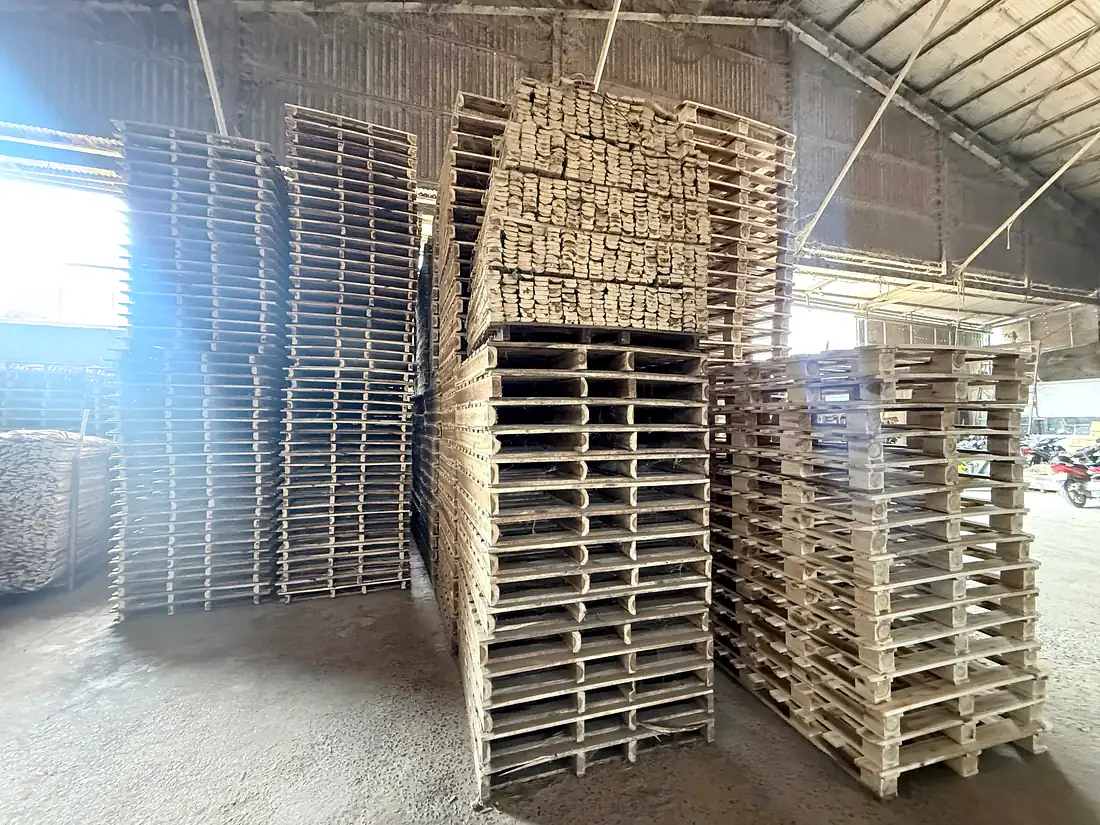 các chồng pallet gỗ tràm thành phẩm và kiện ván xẻ trong xưởng