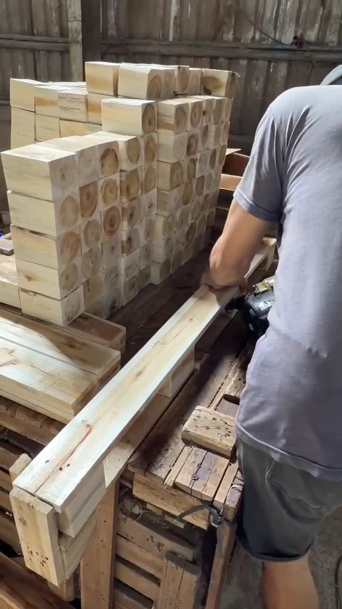 công nhân ghép thanh gỗ tràm cạnh chồng khối gỗ làm chân pallet